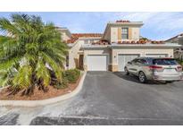 Tan two-story townhome with attached garage and landscaping at 240 W End Dr # 212, Punta Gorda, FL 33950