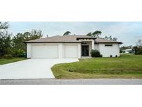 White house with two-car garage and green lawn at 5435 Montego Ln, Port Charlotte, FL 33981