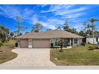 Single-story home with a large driveway, two-car garage, and landscaped yard at 594 Rotonda Cir, Rotonda West, FL 33947