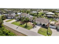 Aerial view of a waterfront home with a large yard and private dock at 9458 Snapper Cir, Port Charlotte, FL 33981