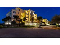 Night view of a luxury condo building with palm trees at 10501 Amberjack Way # 101, Englewood, FL 34224