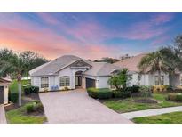 Beautiful one-story home featuring tile roof, manicured landscaping, and brick-paved driveway at 25187 Keygrass Ct, Punta Gorda, FL 33955