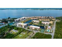 Aerial view of waterfront community with tennis courts, pool, and boat docks at 25188 Marion Ave # D205, Punta Gorda, FL 33950