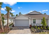 Craftsman style home with gray garage door and landscaped front yard at 43620 Sparrow Dr, Punta Gorda, FL 33982