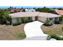 Single-story home with tile roof, driveway, and mature landscaping at 951 Santa Brigida Ct, Punta Gorda, FL 33950
