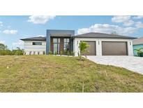Modern two-story house with a three-car garage and landscaped lawn at 9516 President Cir, Port Charlotte, FL 33981