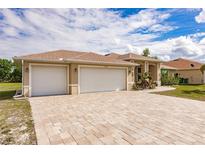 Two-car garage with a paver driveway at 13039 Ridgely Cir, Port Charlotte, FL 33981