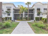 Front view of a two-story building with screened balconies and courtyard at 15960 Grassland Ln # 2722, Punta Gorda, FL 33982