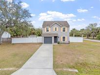 Two-story house with gray siding, orange shutters, and a driveway at 22116 Seaton Ave, Port Charlotte, FL 33954