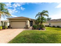 Single-story home with a two-car garage and landscaped front yard at 24667 Rio Villa Lakes Cir, Punta Gorda, FL 33950