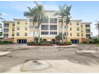 Building exterior featuring a three-story yellow building with palm trees and a circular driveway at 255 W End Dr # 3301, Punta Gorda, FL 33950