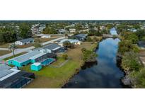 Aerial view of canal-front home with pool and lush landscaping at 3448 Middletown St, Port Charlotte, FL 33952