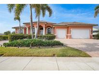 Beautiful 2-story home with tile roof, 3-car garage, and lush landscaping at 3977 La Costa Island Ct, Punta Gorda, FL 33950