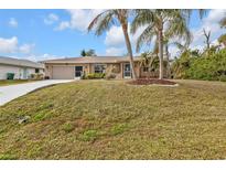 Attractive single-story home with a well-manicured lawn and palm trees at 420 Chamber Nw St, Port Charlotte, FL 33948