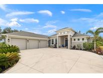 Three-car garage and front entrance of a single-Gathering home at 500 Woodstork Ln, Punta Gorda, FL 33982