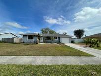 Ranch-style home with a single-car garage and well-manicured lawn at 7570 Berwick St, North Port, FL 34287