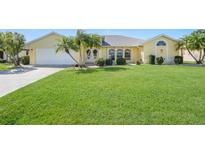 Well-maintained house with a lush green lawn and palm trees at 1717 Nuremberg Blvd, Punta Gorda, FL 33983