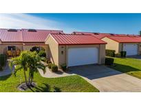 Tan house with red tile roof, white garage door, and landscaped yard at 1780 Deborah Dr # 15, Punta Gorda, FL 33950