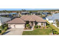 Aerial view of single-Gathering home with a large yard, three car garage, and canal access at 3411 Curacao Ct, Punta Gorda, FL 33950