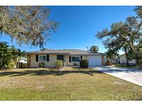 Inviting ranch-style home with a well-manicured lawn and mature trees at 514 Orlando Blvd, Port Charlotte, FL 33954