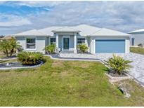 Single-story home with metal roof, paver driveway, and landscaping at 14303 Maysville Cir, Port Charlotte, FL 33981