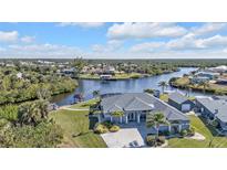 Aerial view of waterfront home with private dock and lush landscaping at 18138 Eau Gallie Cir, Port Charlotte, FL 33948