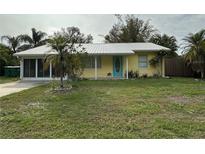 Charming yellow house with a metal roof and a spacious front yard at 2115 Myrtle Ave, Punta Gorda, FL 33950