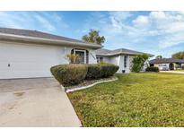 Single-story home with attached garage and manicured lawn at 22259 Priscilla Ave, Port Charlotte, FL 33954