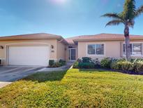 Well-maintained house with a white garage door and lush lawn at 24067 Park Place S Dr # 71, Port Charlotte, FL 33980