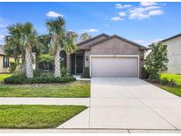 One-story home with gray siding, two-car garage, and palm trees at 2529 Sherman Oak Dr, North Port, FL 34289