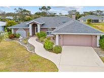 Single-story home with gray roof, attached garage, and landscaped yard at 287 Fortaleza St, Punta Gorda, FL 33983