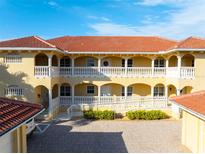 Two-story building with balconies, terracotta roofs, and a courtyard at 3329 Purple Martin Dr # 121, Punta Gorda, FL 33950