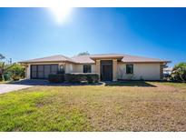 Charming single-story home featuring a well-maintained lawn and a two-car garage at 5991 Gillot Blvd, Port Charlotte, FL 33981