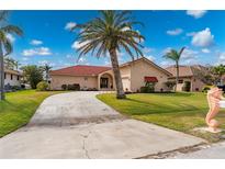 Beautiful one-story home with red tile roof, palm trees, and a large driveway at 674 Monaco Dr, Punta Gorda, FL 33950