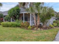 Single-story home with lush landscaping and a screened porch at 1259 Red Oak Ln, Port Charlotte, FL 33948