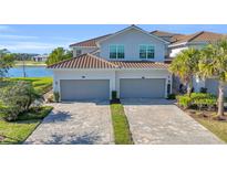 Two-car garage, paver driveway, and lake view at 14033 Black Beauty Dr # 511, Punta Gorda, FL 33955