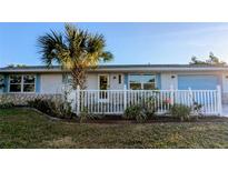 Charming single story home with white picket fence and landscaped yard at 145 Dartmouth Nw Dr, Port Charlotte, FL 33952