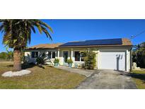 Attractive single-story home with solar panels and a palm tree at 18042 Eau Gallie Cir, Port Charlotte, FL 33948