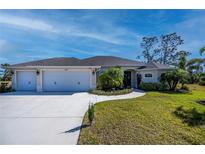 Three-car garage, attractive landscaping, and a welcoming front porch at 269 Mariner Ln, Rotonda West, FL 33947