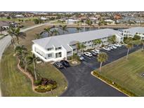 Aerial view of condo building with parking and waterfront access at 3600 Bal Harbor Blvd # 1A, Punta Gorda, FL 33950