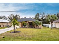 Single-story home with palm trees and a well-manicured lawn at 4398 Appleton Ter, North Port, FL 34286