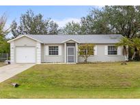 Single-story home with attached garage and neatly landscaped lawn at 5452 Montego Ln, Port Charlotte, FL 33981