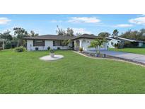 Nice curb appeal! This charming home features a well-manicured lawn and updated facade at 813 Thornton Nw Ave, Port Charlotte, FL 33948