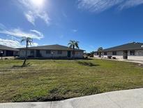 Two-story condo building with grassy yard and palm trees at 24540 Harborview Rd # F1, Punta Gorda, FL 33980