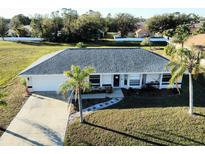 Single-story home with a grey roof and a large backyard at 25075 Palisade Rd, Punta Gorda, FL 33983