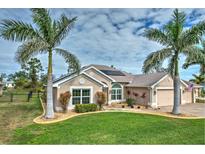 Tan house with solar panels, palm trees, and manicured lawn at 26572 Trinilas Dr, Punta Gorda, FL 33983