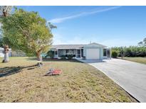 Single-story home with a carport and a well-maintained lawn at 27131 Ann Arbor Ave, Punta Gorda, FL 33983