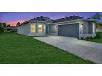 One-story home with gray exterior, two-car garage, and a well-manicured lawn at 4629 Enid Ln, North Port, FL 34288