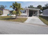 Mobile home exterior with carport and landscaped yard at 5733 Holiday Park Blvd, North Port, FL 34287