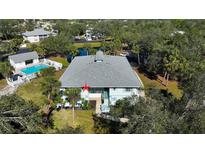 Aerial view of condo building, pool, and lush landscaping at 1051 Forrest Nelson Blvd # M-203, Port Charlotte, FL 33952